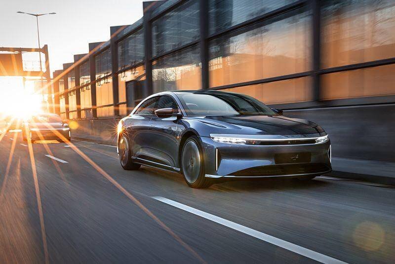 سيارة Lucid Air الكهربائية الفاخرة أثناء القيادة على طريق سريع، تمثل أعلى مدى.