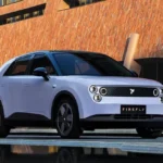 سيارة Nio Firefly 2025 الكهربائية بتصميم هاتشباك عصري متوقفة في شارع حضري حديث أمام مبنى زجاجي فاخر.