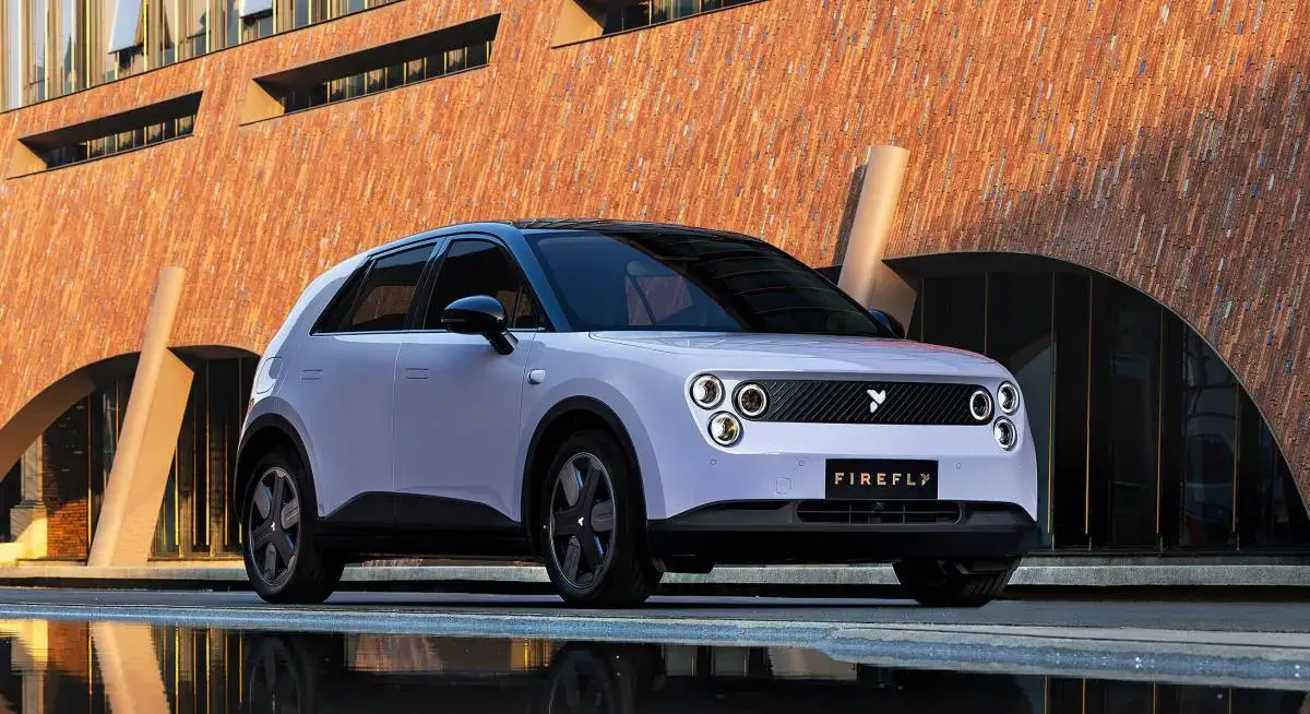 سيارة Nio Firefly 2025 الكهربائية بتصميم هاتشباك عصري متوقفة في شارع حضري حديث أمام مبنى زجاجي فاخر.