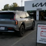 سيارة Kia EV9 كهربائية أمام مركز صيانة بعد ظهور تحذير متعلق بنظام البطارية، في مشهد يعكس مخاوف الاعتمادية لدى بعض ملاك السيارات الكهربائية.