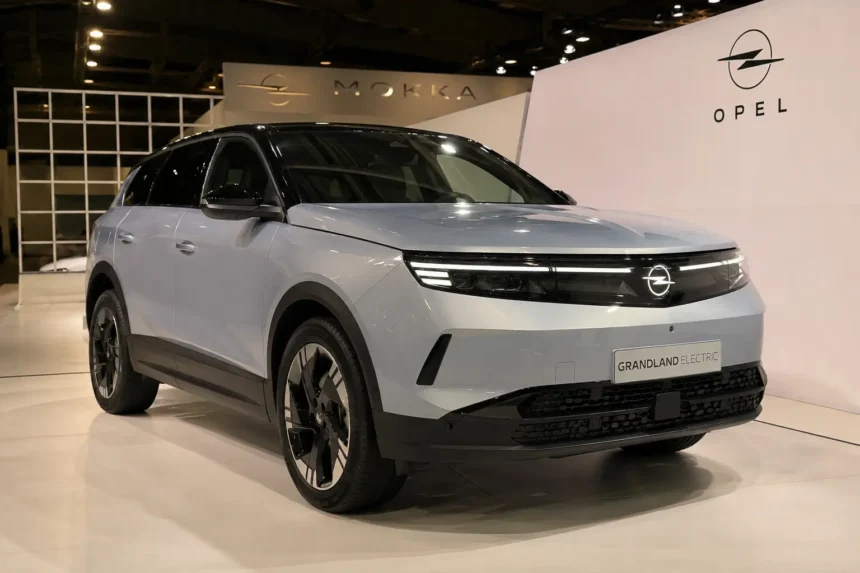 سيارة أوبل SUV كهربائية حديثة معروضة داخل صالة عرض بتصميم أوروبي وإضاءة LED أمامية وتقنيات كهربائية متطورة.