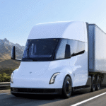 شاحنة Tesla Semi الكهربائية أثناء القيادة على طريق سريع مع تصميم انسيابي حديث وقدرات نقل ثقيل مستقبلية.