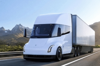 شاحنة Tesla Semi الكهربائية أثناء القيادة على طريق سريع مع تصميم انسيابي حديث وقدرات نقل ثقيل مستقبلية.