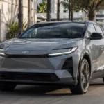 سيارة Toyota C-HR الكهربائية أثناء القيادة في شارع حضري حديث، بتصميم رياضي مدمج يعكس توجه تويوتا الجديد في السيارات الكهربائية.