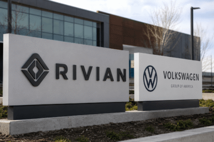 لافتات شركتي Rivian وVolkswagen أمام مبنى حديث في مشهد يعبر عن الشراكة والاستثمار في مستقبل السيارات الكهربائية.