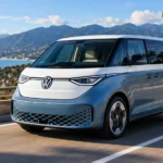 سيارة Volkswagen ID.Buzz الكهربائية أثناء القيادة على طريق ساحلي، بتصميم مستوحى من الحافلة الكلاسيكية ومساحة عائلية واسعة وتقنيات كهربائية حديثة.