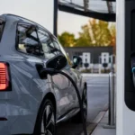 سيارة فولفو EX60 الكهربائية أثناء الشحن السريع باستخدام تقنية Plug & Charge في محطة شحن عامة.