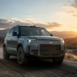 سيارة ROX 01 الجديدة أثناء القيادة على طريق جبلي عند الغروب، بتصميم SUV فاخر يجمع بين القوة والتكنولوجيا.