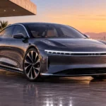 سيارة Lucid Air الكهربائية الفاخرة بتصميم انسيابي أمام منزل عصري وقت غروب الشمس.