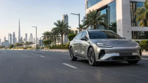 سيارة كهربائية تسير على طريق حديث لتوضيح الفرق بين انبعاثات العادم والبصمة الكربونية عبر دورة حياة السيارة.